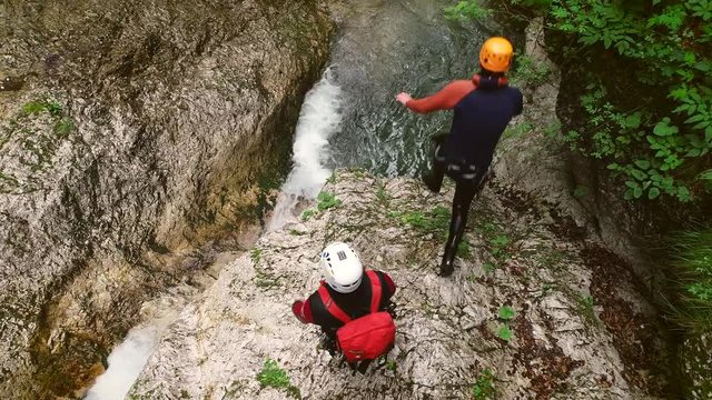Aerial view of a group canyoning and jumping in the water on the Soca river.
