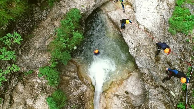 Aerial view of man throwing himself through a sliding rock at Soca river.