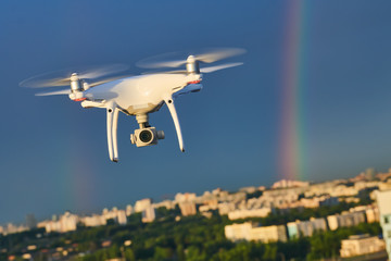 drone flying over city with digital camera at rainbow