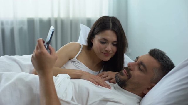 Man addicted to mobile games, ignoring wife flirting in bed, relationship crisis