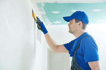 refurbishment. Worker spackling a wall with putty