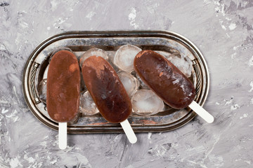 chocolate or coffee ice cream popsicles vintage silver tray shabby concrete background