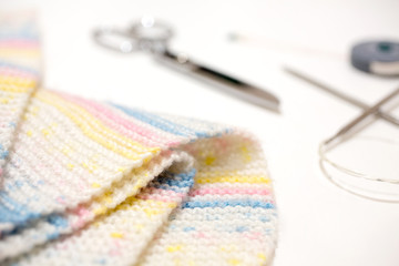 Handmade wool with knitting equipment. Scissors and measuring tape. Frame of knitting needles and scarf on white background. asian.