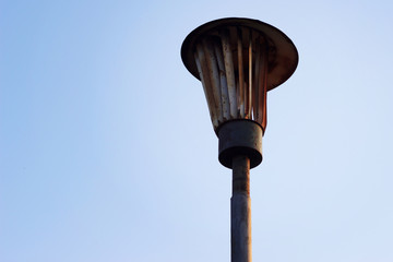 Old rusty lantern on the sky background