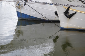 Schiffsrümpfe spiegeln sich im grünen Wasser 