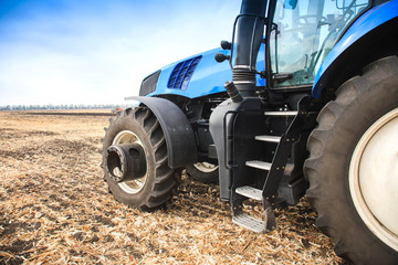 Obraz premium A wheel from a tractor working in the field close up. The concept of agriculture.