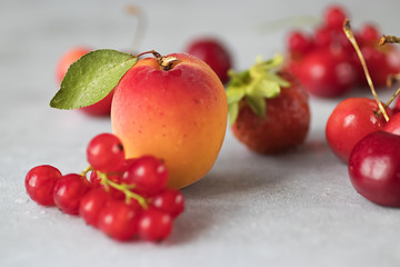 Summer bright berries and fruits on a gray concrete background. The concept of raw food, vegetarianism, healthy eating.