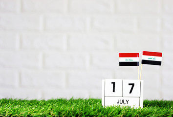 July 17 Wooden calendar and Iraq Flag Concept Iraq national day with space for your text