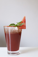 watermelon drink with a cut watermelon and mint leaf