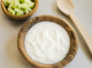 Sliced cucumber and sour cream in wooden bowls
