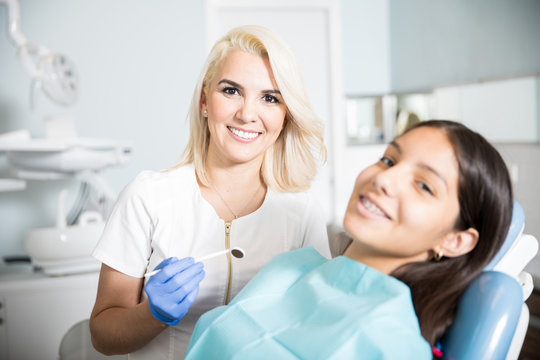 Dentist checking braces on a female patient