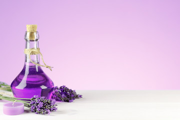 Spa products, aroma candle and lavender flowers on a wooden background