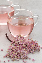 Fototapeta na wymiar Cup of pink elderberry blossom tea