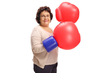 Mature woman wearing a pair of big boxing gloves