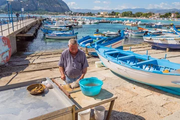 Schilderijen op glas Mondello, Sicily, Europe-10/06 / 2018.Sililian fisherman emptying a fresh fish in the port of Mondello © Demande Philippe