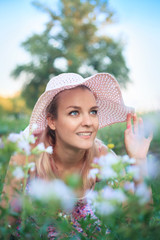 Portrait of a young woman in a hat on nature.