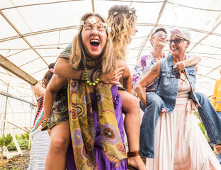 Fototapeta na wymiar girls going crazy in party celebrating with hippies clothes and freedom algernative rebel concept. happiness with girls carrying on backpacks and having fun together in a jardin