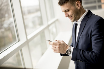 Handsome businessman using smartphone in the office