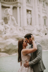 Bride and groom posing in front of Trevi Fountain (Fontana di Trevi), Rome, Italy