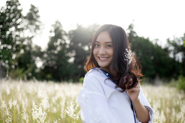 Asian women happy smile on relaxing time at the meadow and grass
