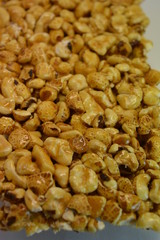 On a white paper background is located and placed from a delicious and sweet grilling of air corn kernels, popcorn with caramel