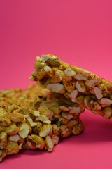 On a bright colorful pink paper background is located and placed from a delicious and sweet grilling of air corn kernels, popcorn with caramel