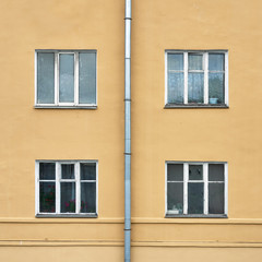 Facade of old residental buildning with windows and a drainpipe