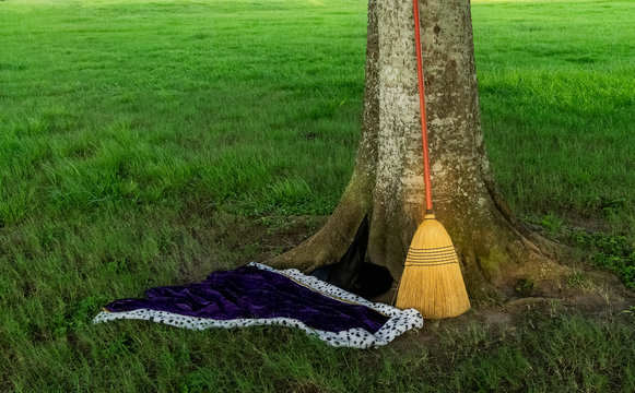 Witch's hat, cape and broom in a parking lot at a local park.