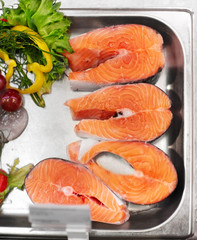 seafood, sale and food concept - chilled fresh salmon fish fillet in metal tray on ice at grocery store