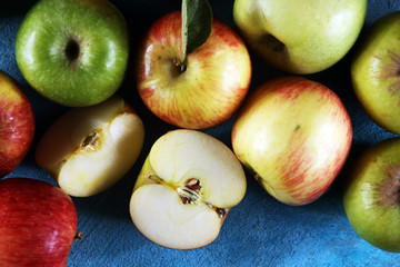 Ripe red apples with leaves on wooden background.
