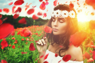 Obraz na płótnie Canvas Beautiful woman in field with a lot of poppy flowers