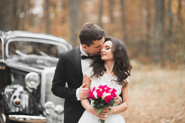 Just married happy couple in the retro car on their wedding