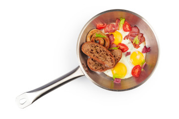 Fried eggs in a frying pan with tomatoes and bread slices isolated on white bacjground