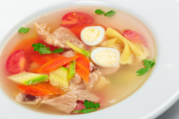 Homemade chicken vegetable soup in a white bowl