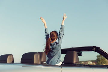 Happy traveler woman in cabrio car