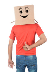 Young man gesturing with a cardboard box on his head with smiley face isolated on white background