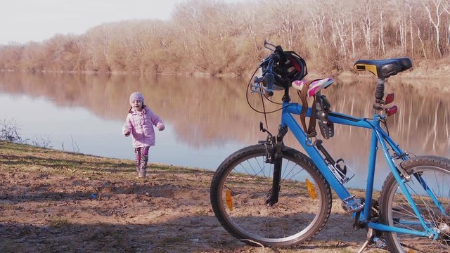 Moldavia, Tiraspol April 1, 2018: A bicycle on the nature by the river. The child walks by the river.