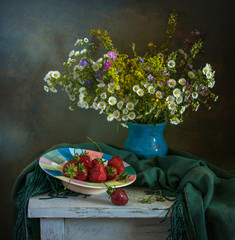 Still-life with flowers and strawberries. Wildflowers. Vintage.