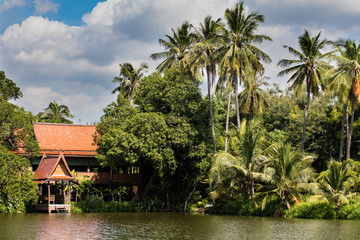 Fototapeta na wymiar River house in a tropical forest in traditional Thai style