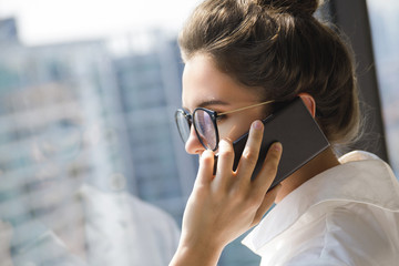 Young businesswoman using smartphone in her office