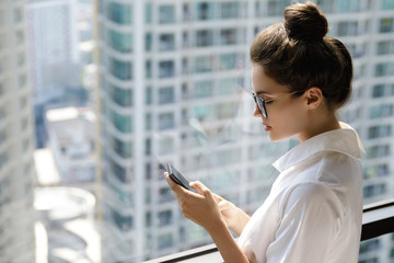 Young businesswoman using smartphone in her office