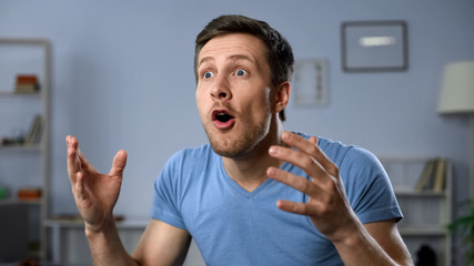 Funny face of sports fan watching final game at home, happy for unexpected goal