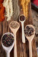 Row of wooden spoons with spices on vintage background, diminishing perspective, close-up, selective focus