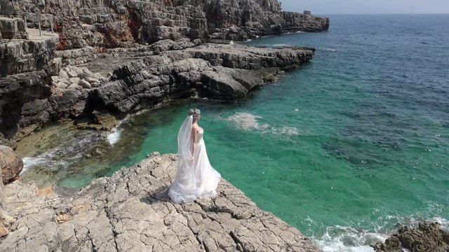 Lonely bride on coastal rocks. Adriatic Sea, Montenegro.