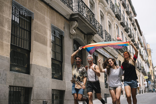 Group of friends with a flag of gay pride in the city of Madrid