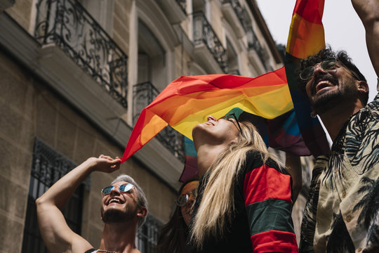 Group of friends with a flag of gay pride in the city of Madrid
