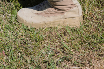 Color of military infantry boots and sole coinciding with color of an autumn grass