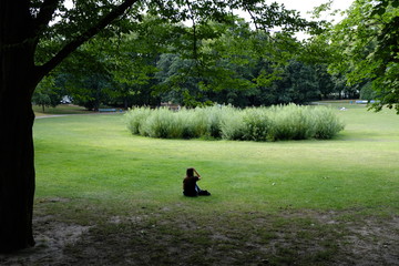 Ayoung woman is resting on a meadow in a park in Berlin-Germany