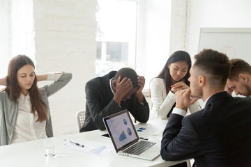 Disappointed diverse millennial team feeling despair because of bad results or falling statistics,...