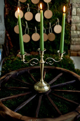 Seating plan, wedding decor in rustic style. Moss, bark, wood, crafting cards. The candlestick on the old wheel. Candles burn